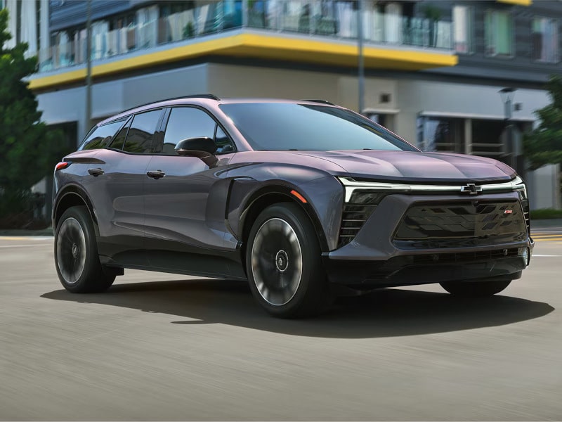 A sleek gray SUV driving through an urban environment, showcasing modern design and luxury features.