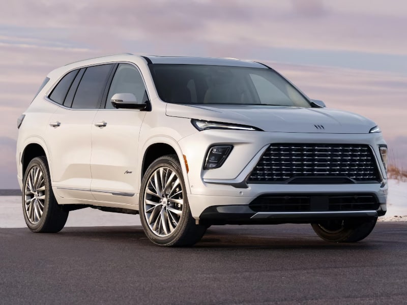 White SUV parked on a scenic road, showcasing sleek design and modern features under a cloudy sky.