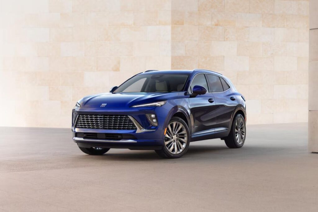 Blue SUV parked against a light stone wall, showcasing sleek design and modern features.
