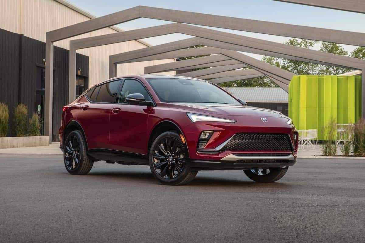 Red SUV parked in an outdoor urban setting with modern architecture in the background.