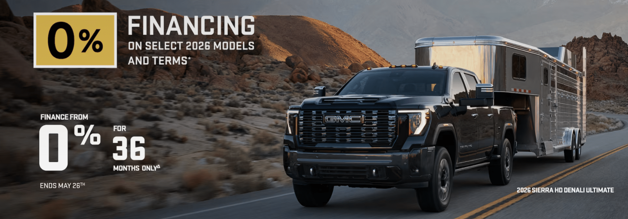 GMC Sierra HD Denali towing a trailer in a desert, offering 0% financing for select 2026 models until May 26.
